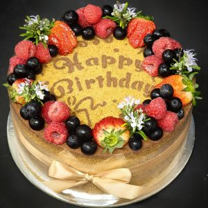 Honey cake with cake crumbs and berries