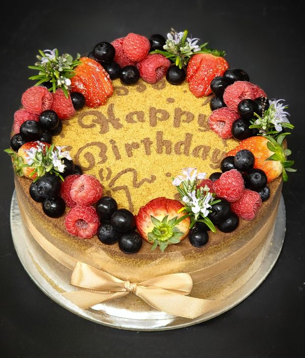 Honey cake with cake crumbs and berries