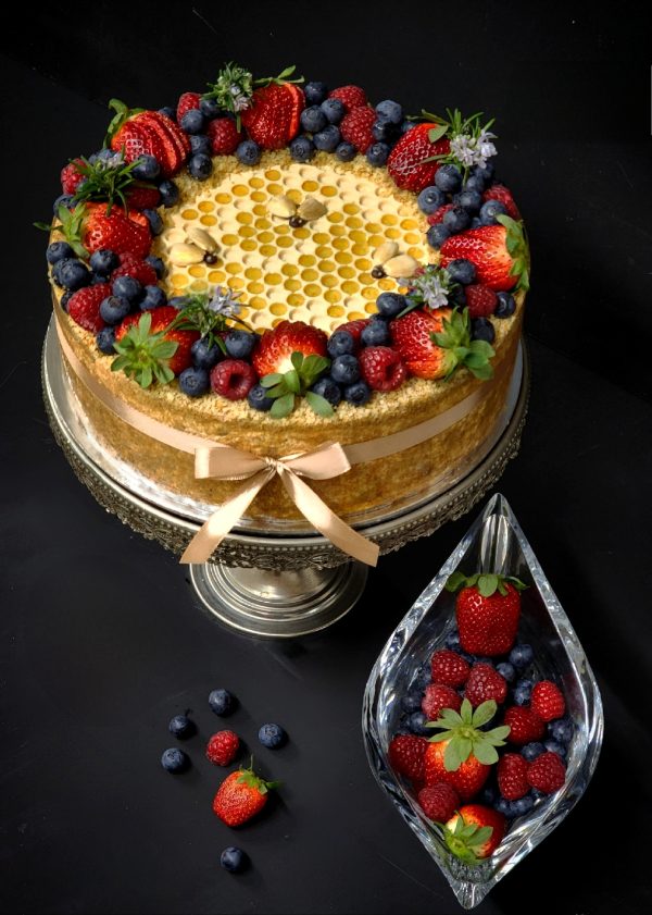 Honey cake with walnuts, honeycomb and berries